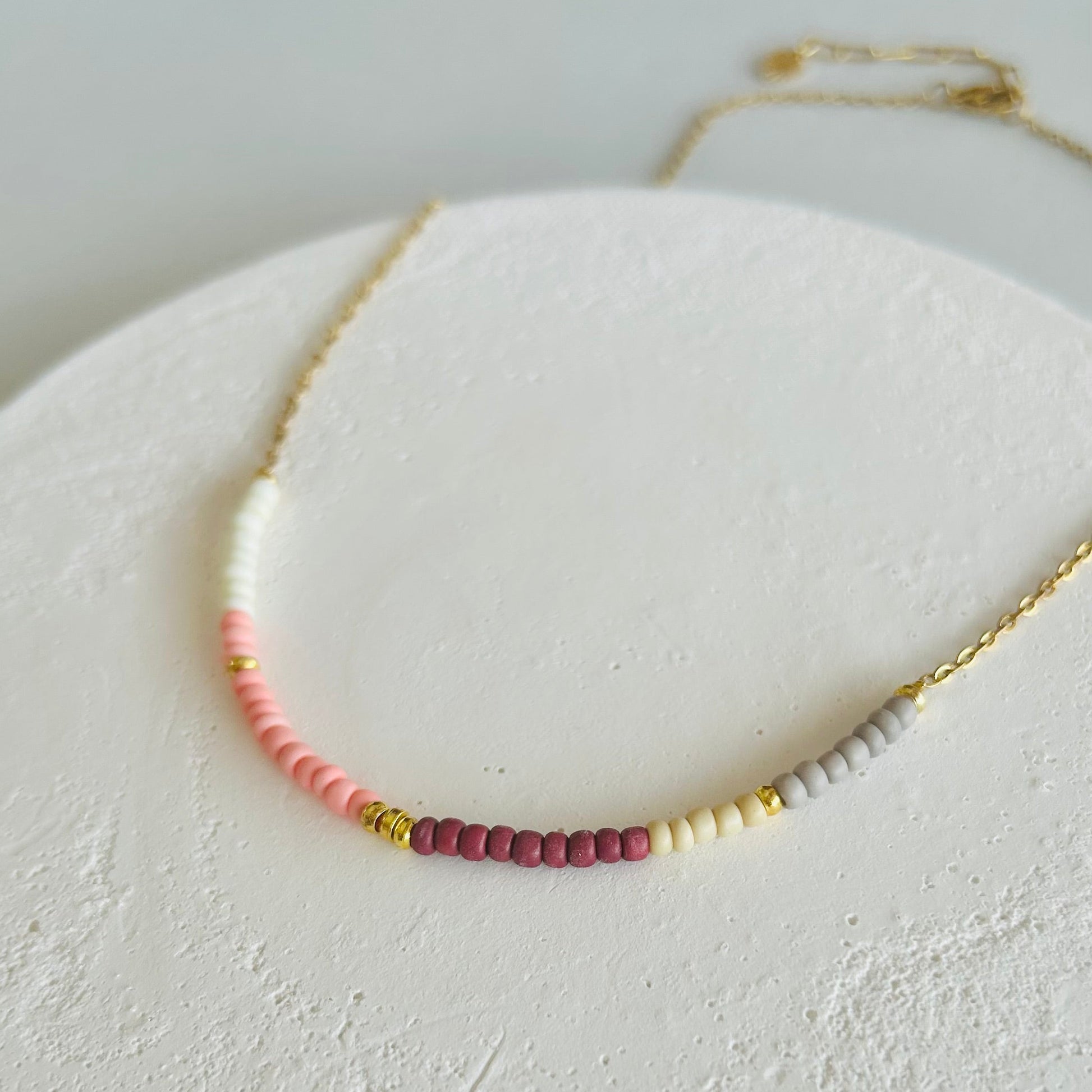 Necklace with small beads on a textured white surface