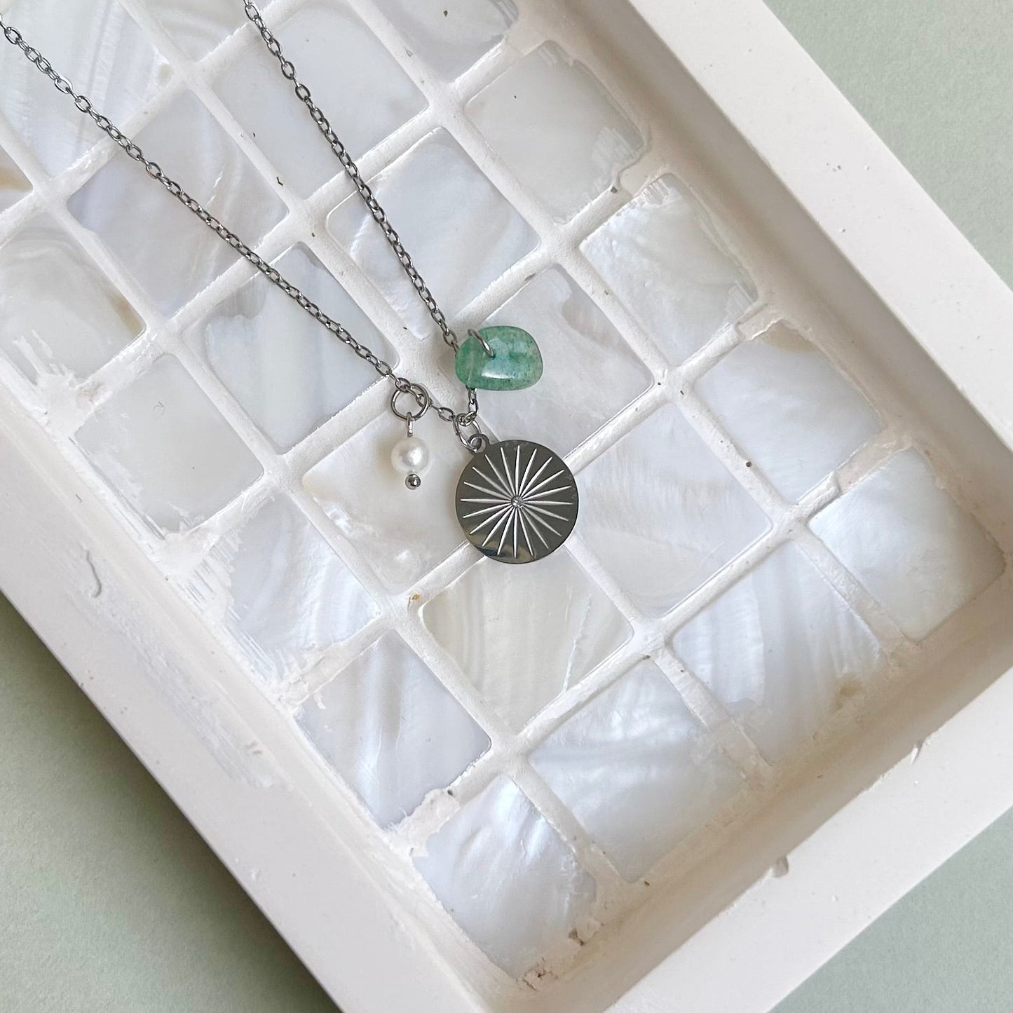 Necklace with a pendant on a white shell in a display case