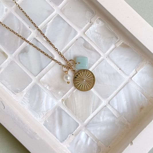 Necklace with a pendant in a jewelry box on a light green background